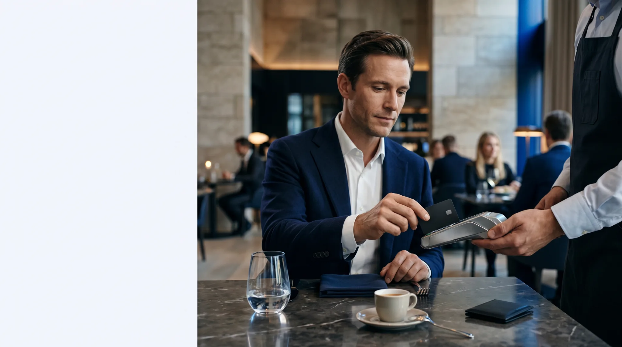 A guest paying by card while a server holds a handheld terminal at a lounge bar